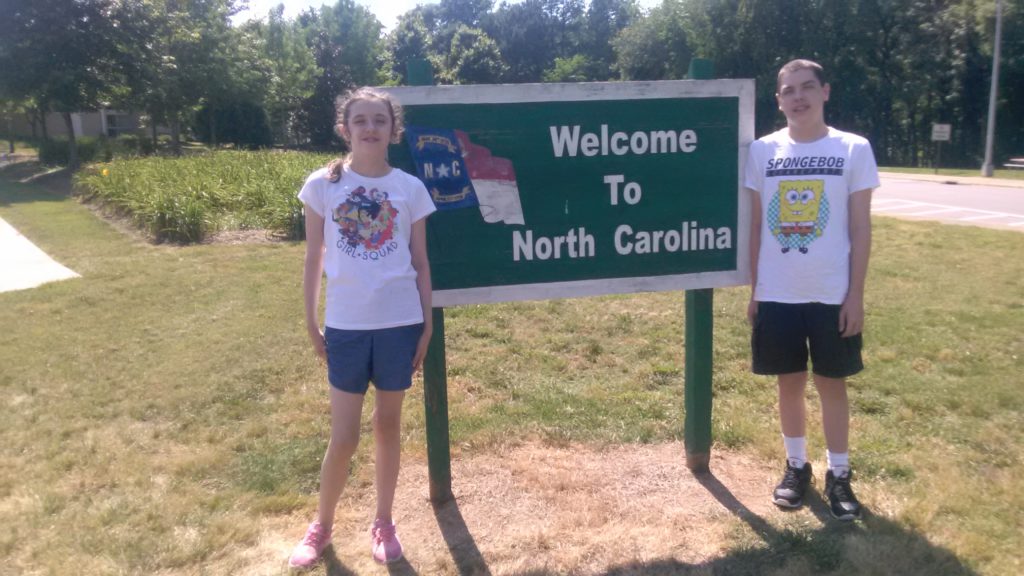 kids in front of welcome to north carolina sign