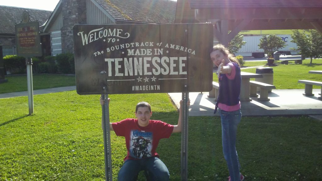 kids next to tennessee sign